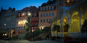 a group of buildings in a city at night at Promenáda Romantic Hotel in Karlovy Vary