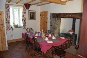 a dining room with a table with a red table cloth at Middle Woodbatch B&B in Bishops Castle