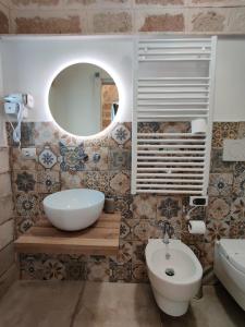 a bathroom with a white sink and a mirror at RomAntica in Polignano a Mare