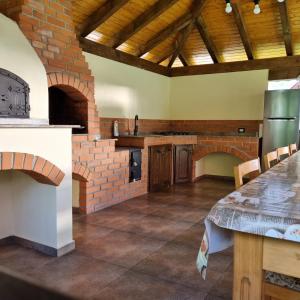a large kitchen with a table and a brick wall at Pensiunea casa Rareș in Curtea de Argeş
