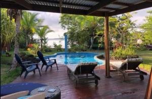 a patio with chairs and a swimming pool at Dolphin Bay Hideaway in Bocas del Toro