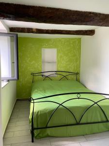 ein grünes Bett in einem Zimmer mit grüner Wand in der Unterkunft Casa Francesco App Giulia in Rocchetta