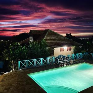 una piscina frente a una casa por la noche en Westhill Bungalows & Diving en Sabana Westpunt