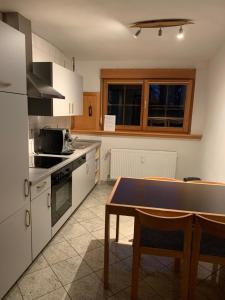 a kitchen with white cabinets and a table in it at Ferienwohnung am Süd-Schwarzwald 1 in Murg