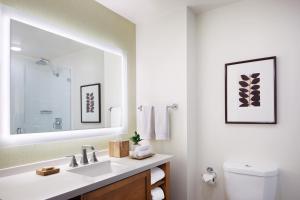 a white bathroom with a sink and a mirror at Ambrose Hotel in Los Angeles