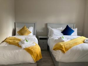 dos camas sentadas una al lado de la otra en un dormitorio en The Leitrim Inn and Blueway Lodge en Leitrim