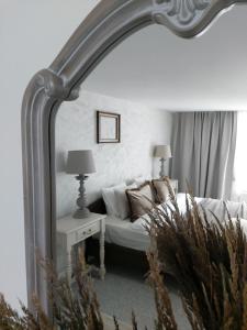 a large mirror in a bedroom with a bed at Naktakės apartamentai in Kupiškis