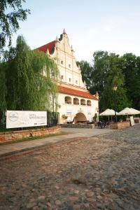 a large white building with a sign in front of it at Spichlerz na Krakowskiej in Kazimierz Dolny