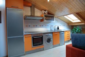 a kitchen with a stove and a washing machine at Apartamento Los Mesones in Ágreda