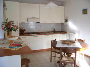 グレーヴェ・イン・キアンティにあるAppartamenti Il Girasoleの白いキャビネットとテーブルと椅子のあるキッチン +27枚の写真