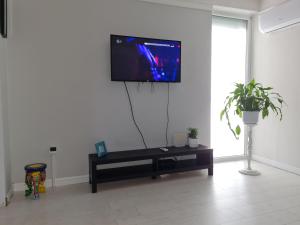 uma sala de estar com uma televisão de ecrã plano na parede em Come.in em Kiskunfélegyháza