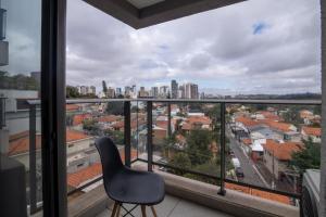 a chair sitting on a balcony with a view of a city at 360 Vila Madalena in Sao Paulo