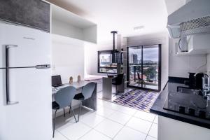 uma cozinha com um lavatório e uma mesa com cadeiras em 360 Vila Madalena em São Paulo