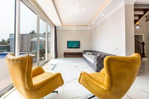 a living room with two chairs and a couch at LA VILLA CELINE- Luxury Sea View Villa with Private Infinity Pool in Islamlar-Kalkan in Kalkan
