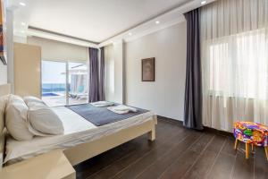 a bedroom with a bed and a large window at LA VILLA CELINE- Luxury Sea View Villa with Private Infinity Pool in Islamlar-Kalkan in Kalkan +54 photos