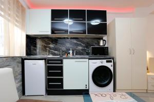 a kitchen with white cabinets and a washer at Deluxe 2 Studios City Center in Burgas City +32 photos