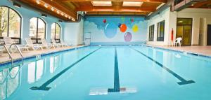a large swimming pool with blue water in a building at Penn Wells Hotel in Wellsboro