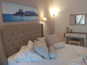 una camera da letto con un letto con cuscini bianchi di Villa Soula Kaliva a Kefalos