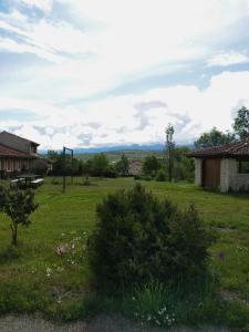 a field of grass with a house and mountains in the distance at LA SOLANILLA -Casas Rurales in Torre Val de San Pedro