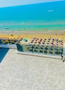 ein Bild eines Strandes mit Sonnenschirmen und dem Meer in der Unterkunft Luxury Penthouse Shkembi Kavajes in Durrës