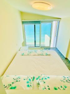 1 Schlafzimmer mit 2 Betten und einem großen Fenster in der Unterkunft Luxury Penthouse Shkembi Kavajes in Durrës