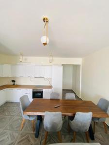 eine Küche mit einem Holztisch und Stühlen in der Unterkunft Luxury Penthouse Shkembi Kavajes in Durrës