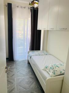 ein kleines Schlafzimmer mit einem Bett und einem Fenster in der Unterkunft Luxury Penthouse Shkembi Kavajes in Durrës