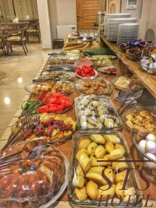- un buffet avec de nombreux plateaux de nourriture sur une table dans l'établissement STS Hotel Luleburgaz, à Lüleburgaz