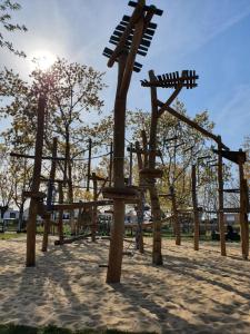 a park with a playground with wooden swings at Maison Les Embruns avec piscine collective in La Faute-sur-Mer