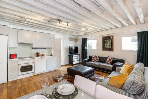 ein Wohnzimmer mit einem Sofa und einem Tisch in der Unterkunft BNBHolder Charming Duplex Attic SOL in Madrid