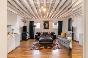 ein Wohnzimmer mit einem Sofa und einem Tisch in der Unterkunft BNBHolder Charming Duplex Attic SOL in Madrid