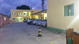 un estacionamiento con autos estacionados al lado de un edificio en Hotel Joabi, en São José dos Campos