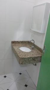 a bathroom with a sink and a mirror at Hotel Joabi in São José dos Campos