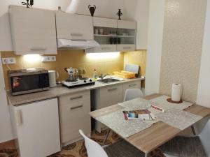 a small kitchen with a table and a microwave at Fabi Apart in Hévíz +21 photos