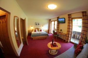 ein Hotelzimmer mit einem Bett und einem Tisch in der Unterkunft Gästehaus Pilz Schladming in Schladming