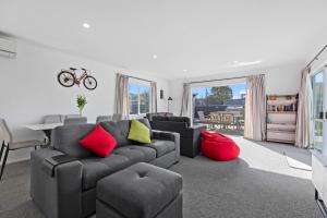 a living room with a couch and a table at Lazy Sun Daze - Papamoa Holiday Home in Papamoa