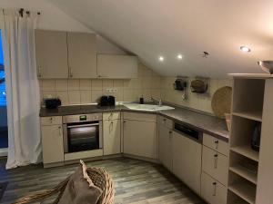 a kitchen with white cabinets and a sink at Im Herzen Bayerns in Töging am Inn