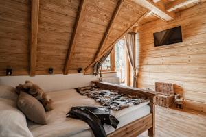 a large bed in a room with wooden walls at Nosalowski Wypas in Zakopane
