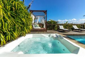 bañera en una terraza junto a la piscina en Morada da Praia do Rosa Pousada, en Praia do Rosa