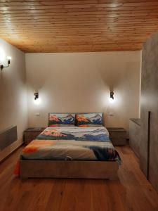 1 dormitorio con cama y techo de madera en Appartamento con taverna nel paese di Morgex en Morgex