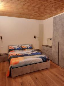 una camera con letto e soffitto in legno di Appartamento con taverna nel paese di Morgex a Morgex