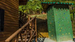 un mur d'escalade à côté d'un bâtiment en bois dans l'établissement La Quinta Dimensión Glamping Resort, à El Peñol