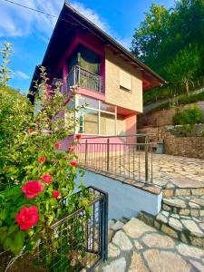 a house with a balcony and flowers in front of it at Neretva River Guesthouse in Konjic