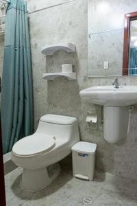 a bathroom with a toilet and a sink at Hotel Andy in Atacames