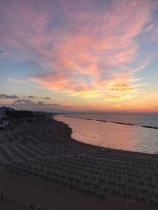 una spiaggia con sedie e l'oceano al tramonto di Kennedy Apartment a Termoli