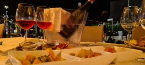 uma mesa com dois copos de vinho e um prato de comida em Kennedy Apartment em Termoli