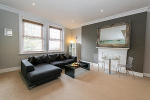 a living room with a black couch and a fireplace at Cosy Urban Oasis - Quirky 2-Bed Town Centre Apartment in Bournemouth