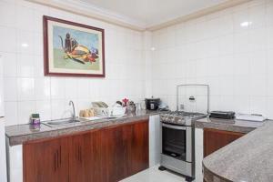a kitchen with a sink and a stove top oven at Hotel Andy in Atacames