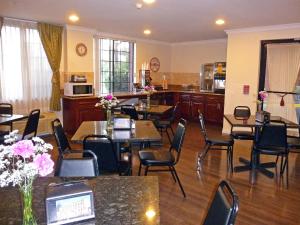 a dining room with tables and chairs and a kitchen at Howard Johnson by Wyndham Pasadena in Pasadena