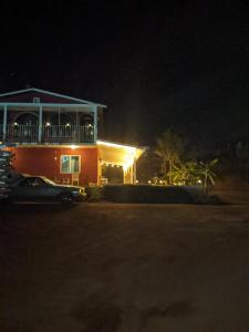 Villa De Coral في فالي دي جوادالوبي: منزل في الليل مع سيارة متوقفة أمامه